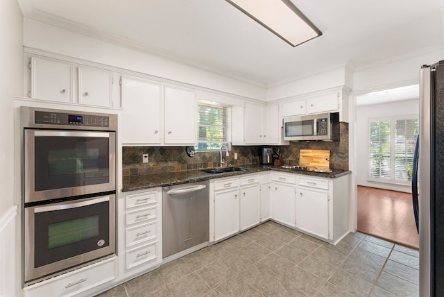 25607 Spring Ridge Dr, Spring, TX 77386 - kitchen featuring stainless steel appliances, healthy amount of natural light, crown molding, white cabinets, and decorative backsplash