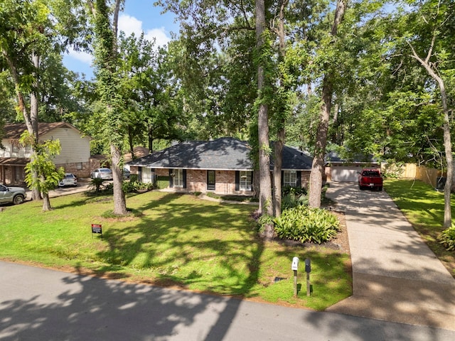 25607 Spring Ridge Dr, Spring, TX 77386 - ranch-style house featuring concrete driveway, a front lawn, and brick siding