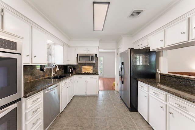 25607 Spring Ridge Dr, Spring, TX 77386 - kitchen featuring stainless steel appliances, crown molding, white cabinets, backsplash, and dark stone countertops