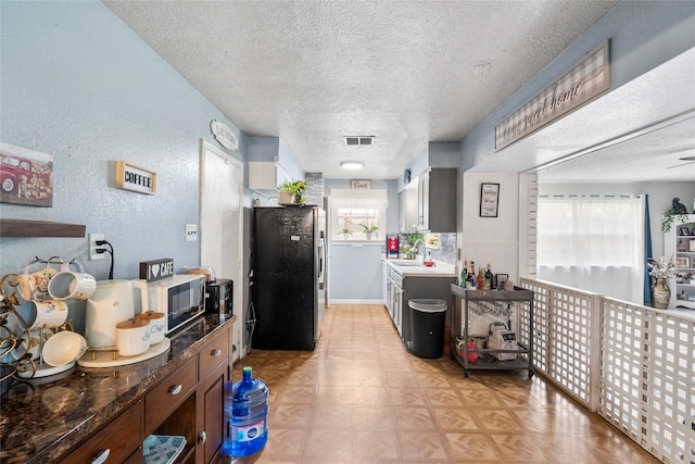 10507 Kirkhill Dr, Houston, TX 77089 - kitchen featuring freestanding refrigerator, a textured ceiling, a textured wall, and light floors