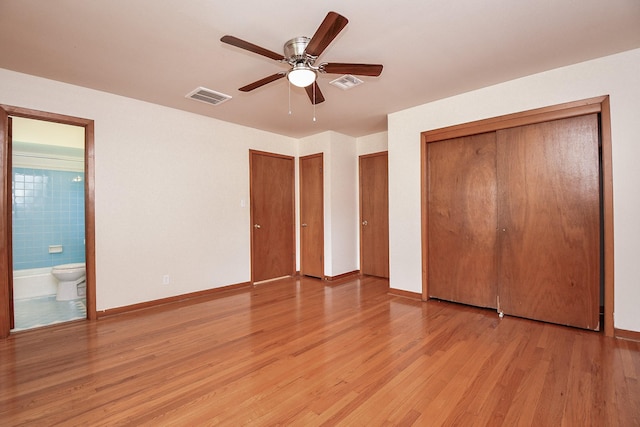 1215 W 31st St, Houston, TX 77018 - unfurnished bedroom featuring light wood finished floors, two closets, ensuite bath, and a ceiling fan