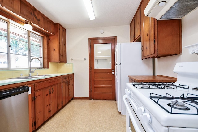 1215 W 31st St, Houston, TX 77018 - kitchen featuring stainless steel dishwasher, white range with gas cooktop, exhaust hood, and light countertops
