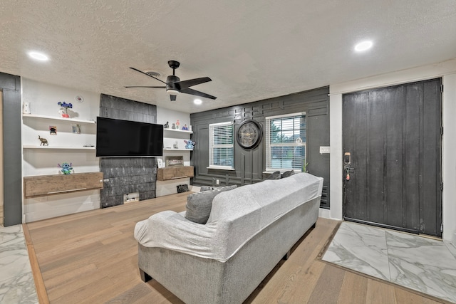 826 Rosewick St, Houston, TX 77015 - living room with ceiling fan, marble look tiles, a textured ceiling, recessed lighting, and a multi sided fireplace