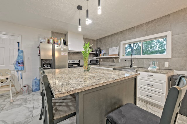 826 Rosewick St, Houston, TX 77015 - kitchen with light marble finish flooring, stainless steel appliances, white cabinetry, a kitchen island, and a textured ceiling