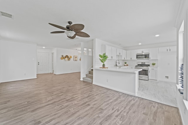 6310 Mountain Pines Ln, Katy, TX 77449 - kitchen featuring stainless steel appliances, open floor plan, light countertops, ceiling fan, and a peninsula