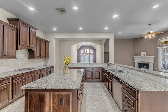 2206 Chelsea Creek Ln, Spring, TX 77386 - kitchen with ceiling fan, appliances with stainless steel finishes, a kitchen island, tasteful backsplash, and arched walkways