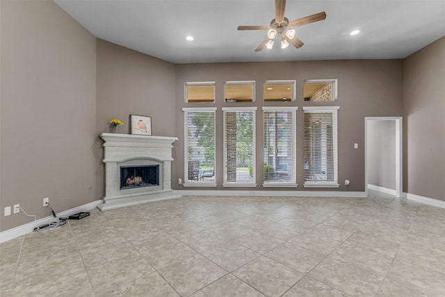 2206 Chelsea Creek Ln, Spring, TX 77386 - unfurnished living room with ceiling fan, a fireplace with raised hearth, light tile patterned floors, and recessed lighting
