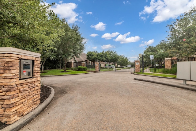 2206 Chelsea Creek Ln, Spring, TX 77386 - view of asphalt road with a gate, a gated entry, and curbs
