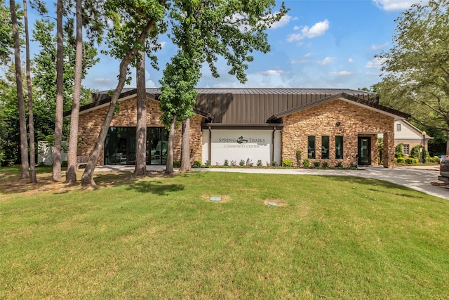 2206 Chelsea Creek Ln, Spring, TX 77386 - view of front of home featuring stone siding, a front lawn, a metal roof, and a standing seam roof