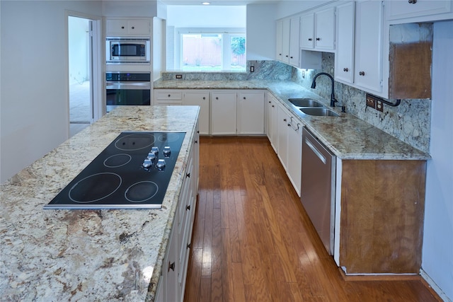 2231 Round Lake Dr, Houston, TX 77077 - kitchen with stainless steel appliances, dark wood-style floors, white cabinetry, light stone countertops, and decorative backsplash