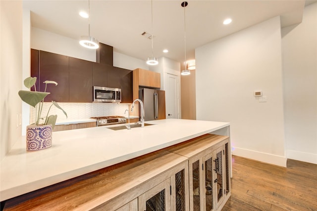 1919 Rosewood St, Houston, TX 77004 - kitchen with appliances with stainless steel finishes, wood finished floors, hanging light fixtures, backsplash, and recessed lighting