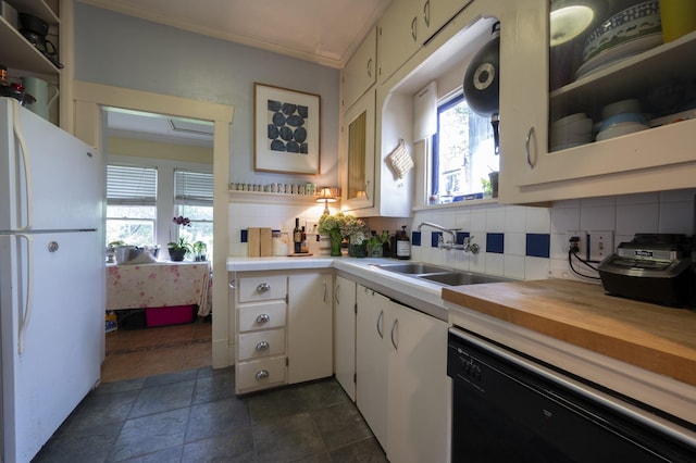 618 Wendel St, Houston, TX 77009 - kitchen featuring freestanding refrigerator, black dishwasher, white cabinets, tasteful backsplash, and healthy amount of natural light