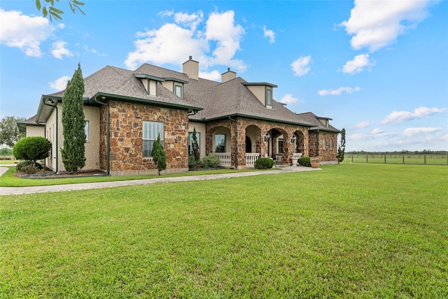 2750 Fm 563, Anahuac, TX 77514 - french provincial home featuring a chimney, a shingled roof, covered porch, and stone siding