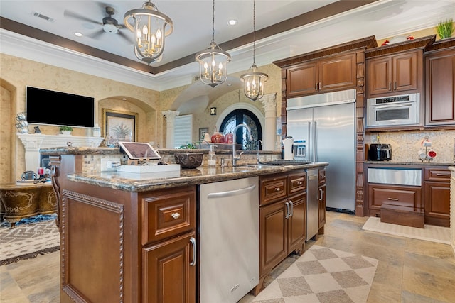 2750 Fm 563, Anahuac, TX 77514 - kitchen featuring appliances with stainless steel finishes, a center island with sink, a chandelier, dark stone counters, and a warming drawer