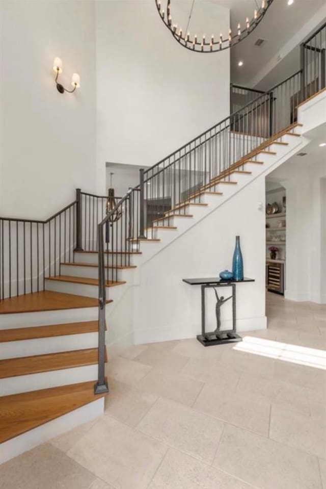 7526 Janak Dr, Houston, TX 77055 - stairs with a towering ceiling, a chandelier, and tile patterned floors