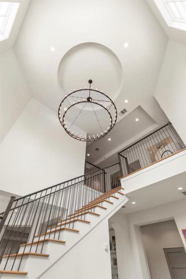 7526 Janak Dr, Houston, TX 77055 - stairs featuring a high ceiling, a skylight, recessed lighting, and a chandelier