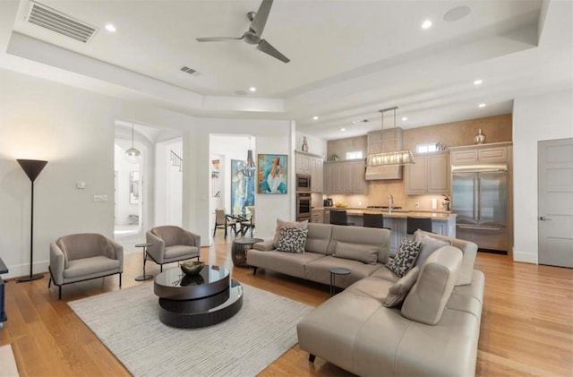 7526 Janak Dr, Houston, TX 77055 - living area with a raised ceiling, ceiling fan, recessed lighting, and light wood-style floors
