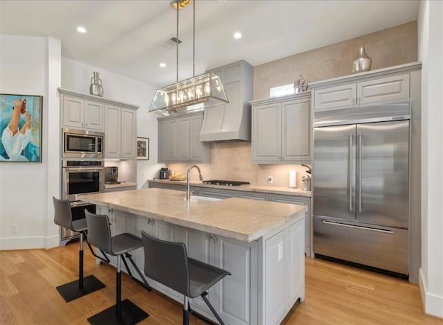 7526 Janak Dr, Houston, TX 77055 - kitchen with built in appliances, gray cabinets, light stone counters, light wood-style flooring, and recessed lighting