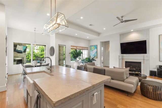7526 Janak Dr, Houston, TX 77055 - kitchen featuring a ceiling fan, a fireplace, light wood-style floors, recessed lighting, and open floor plan