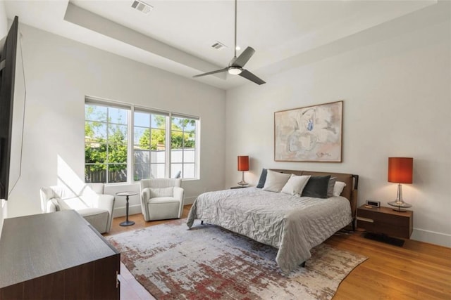 7526 Janak Dr, Houston, TX 77055 - bedroom featuring wood finished floors, a ceiling fan, and a raised ceiling
