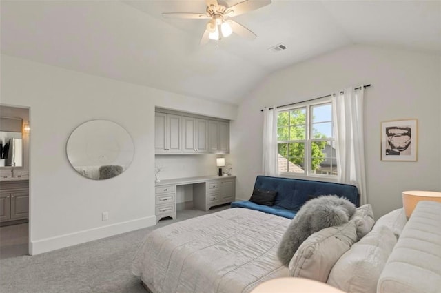7526 Janak Dr, Houston, TX 77055 - bedroom with vaulted ceiling, carpet, built in desk, ceiling fan, and ensuite bath
