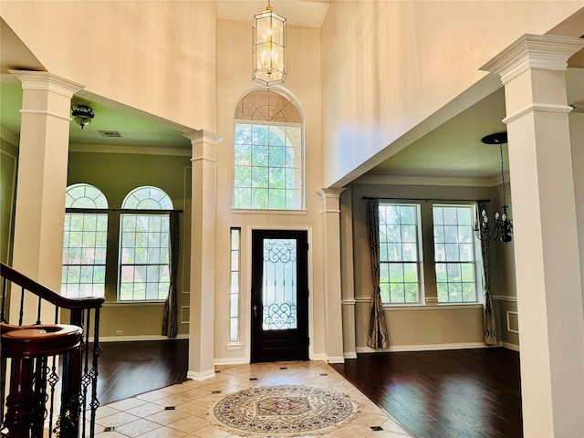 5403 Emerald Pointe Ln, Sugar Land, TX 77479 - foyer with decorative columns, a high ceiling, a chandelier, wood finished floors, and crown molding