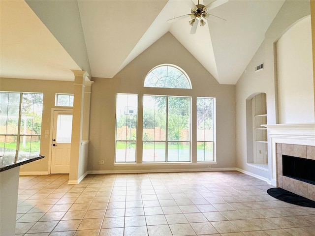 5403 Emerald Pointe Ln, Sugar Land, TX 77479 - unfurnished living room featuring light tile patterned floors, ceiling fan, a tile fireplace, built in shelves, and vaulted ceiling