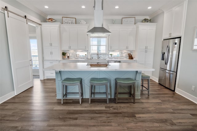 1301 Lagoon Dr, Crystal Beach, TX 77650 - kitchen featuring stainless steel fridge, wall chimney exhaust hood, white cabinets, a kitchen island, and a barn door
