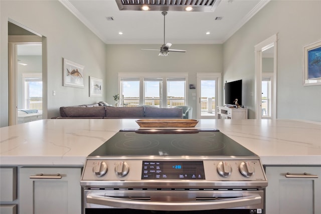 1301 Lagoon Dr, Crystal Beach, TX 77650 - kitchen with stainless steel range with electric stovetop, open floor plan, ceiling fan, plenty of natural light, and crown molding