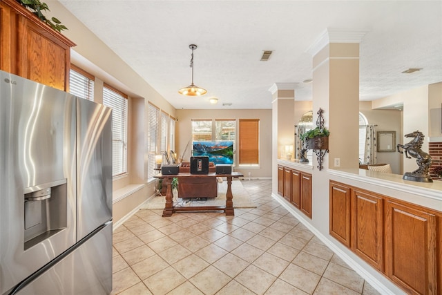 23702 Whispering Wind, Katy, TX 77494 - kitchen with stainless steel fridge with ice dispenser, light countertops, open floor plan, light tile patterned flooring, and brown cabinets