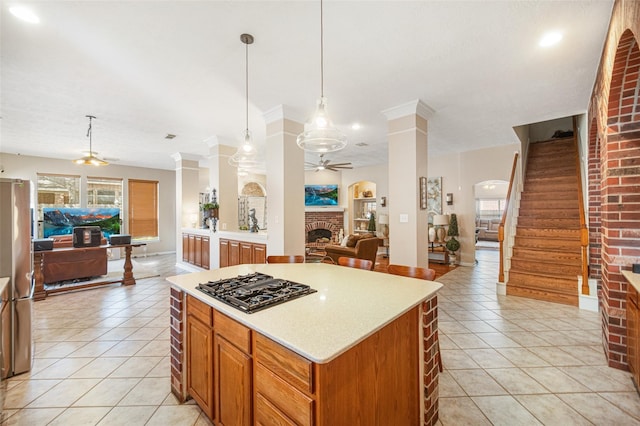 23702 Whispering Wind, Katy, TX 77494 - kitchen featuring open floor plan, ceiling fan, black gas stovetop, a brick fireplace, and ornate columns