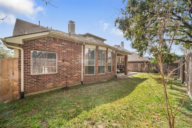 23702 Whispering Wind, Katy, TX 77494 - rear view of property featuring brick siding, a chimney, and a fenced backyard