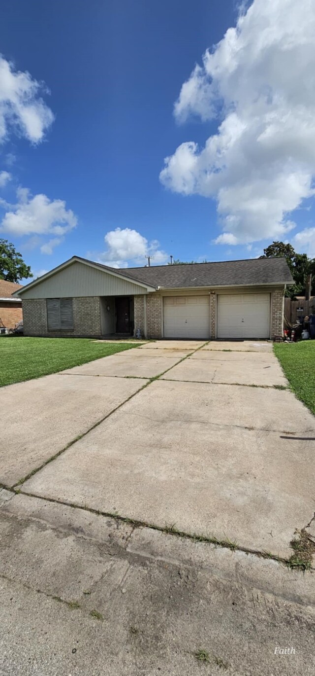 2714 6th Ave N, Texas City, TX 77590 - view of front of home with brick siding, concrete driveway, a front lawn, and a garage