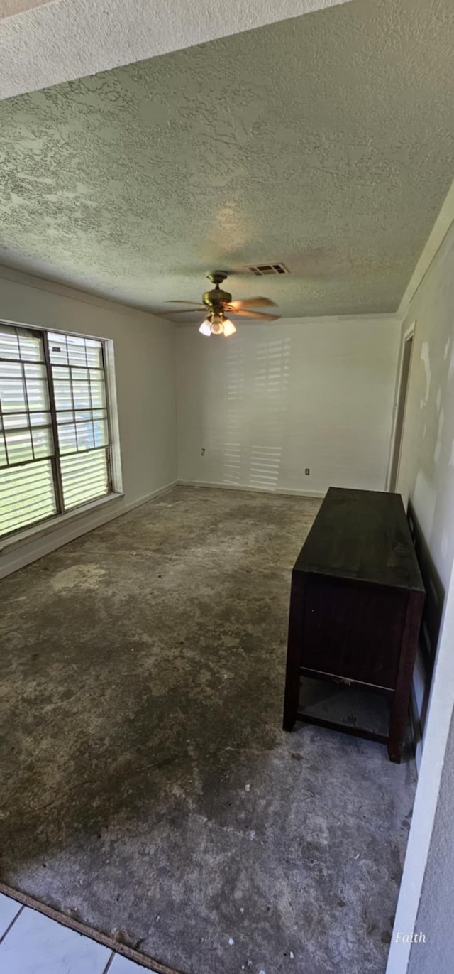 2714 6th Ave N, Texas City, TX 77590 - unfurnished living room featuring a textured ceiling, a ceiling fan, and concrete floors