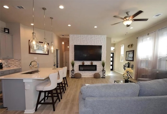 917 Crystal Bend Ln, Katy, TX 77493 - living room with a ceiling fan, light wood-style flooring, a fireplace, and recessed lighting