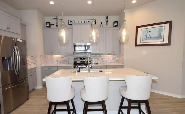 917 Crystal Bend Ln, Katy, TX 77493 - kitchen with appliances with stainless steel finishes, gray cabinetry, decorative backsplash, light wood-style floors, and recessed lighting