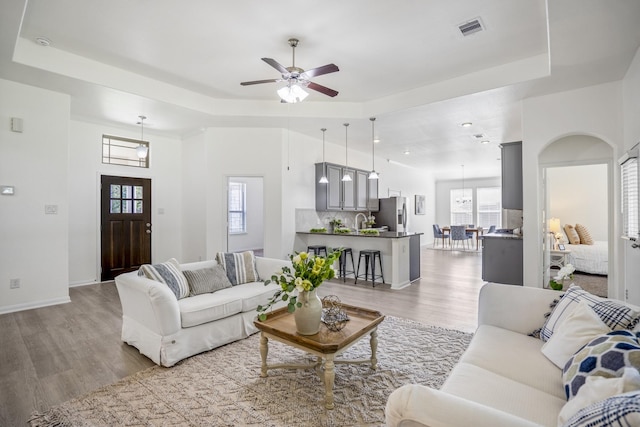16070 Deer Pines Dr, Conroe, TX 77303 - living area featuring a raised ceiling, light wood-type flooring, healthy amount of natural light, and a ceiling fan