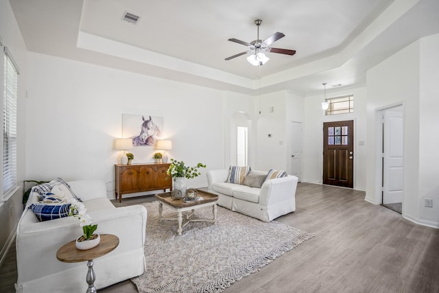16070 Deer Pines Dr, Conroe, TX 77303 - living room with a tray ceiling, arched walkways, a ceiling fan, and wood finished floors