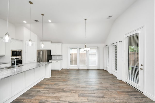 28430 Sycamore Falls Ln, Fulshear, TX 77441 - kitchen with appliances with stainless steel finishes, a chandelier, white cabinets, high vaulted ceiling, and tasteful backsplash