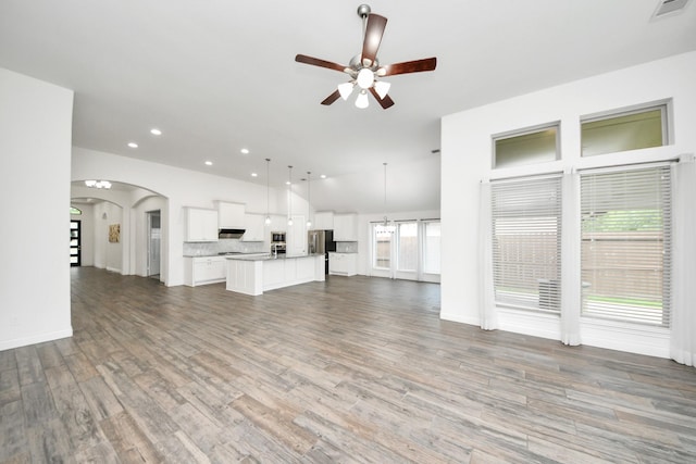 28430 Sycamore Falls Ln, Fulshear, TX 77441 - unfurnished living room with recessed lighting, a ceiling fan, arched walkways, wood finished floors, and lofted ceiling