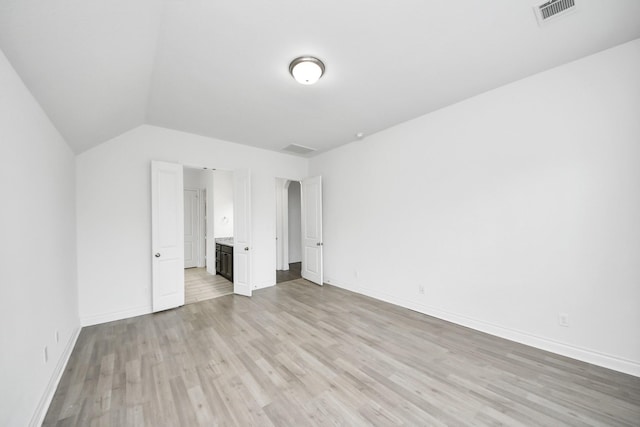 28430 Sycamore Falls Ln, Fulshear, TX 77441 - unfurnished bedroom with light wood finished floors, vaulted ceiling, and ensuite bath