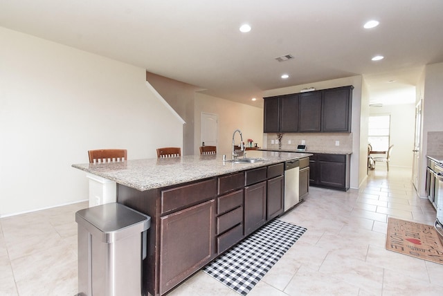 4302 Lisboa Cir, Katy, TX 77493 - kitchen featuring recessed lighting, stainless steel dishwasher, a kitchen island with sink, backsplash, and light stone counters