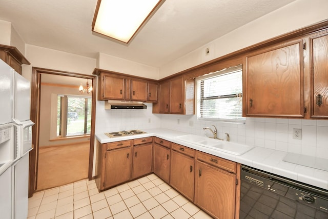 8311 Everleaf Dr, Spring, TX 77379 - kitchen with dishwasher, under cabinet range hood, decorative backsplash, light tile patterned flooring, and brown cabinetry