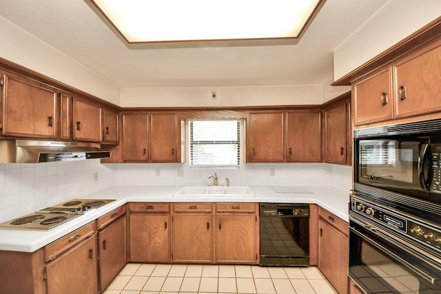 8311 Everleaf Dr, Spring, TX 77379 - kitchen with black appliances, under cabinet range hood, backsplash, and light countertops