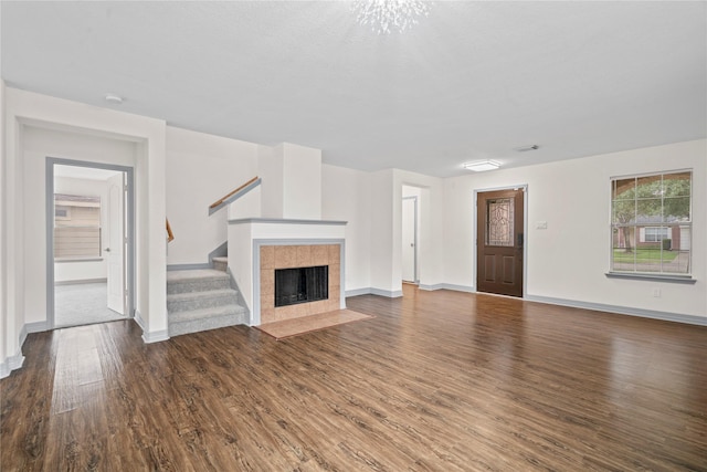 29418 Legends Hill Dr, Spring, TX 77386 - unfurnished living room with wood finished floors, stairway, and a tiled fireplace