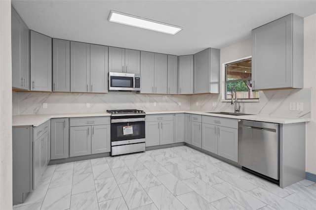 29418 Legends Hill Dr, Spring, TX 77386 - kitchen with stainless steel appliances, gray cabinets, light marble finish floors, light countertops, and backsplash