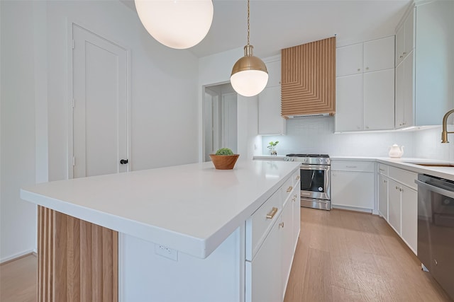 4109 Castor St Unit B, Houston, TX 77022 - kitchen featuring stainless steel appliances, light wood-style floors, a center island, light countertops, and white cabinetry