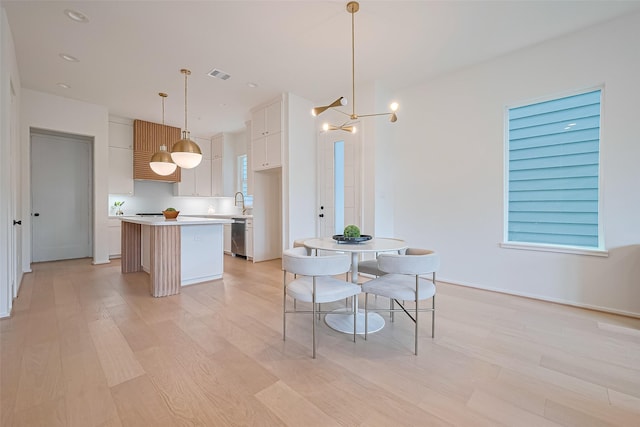 4109 Castor St Unit B, Houston, TX 77022 - kitchen featuring a center island, dishwasher, light wood-style flooring, light countertops, and white cabinetry