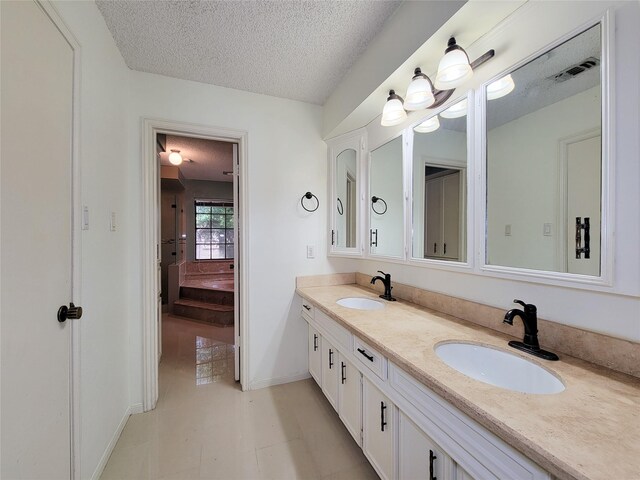 3 Thunderbird Cir, Baytown, TX 77521 - full bathroom featuring a textured ceiling, double vanity, and ensuite bathroom
