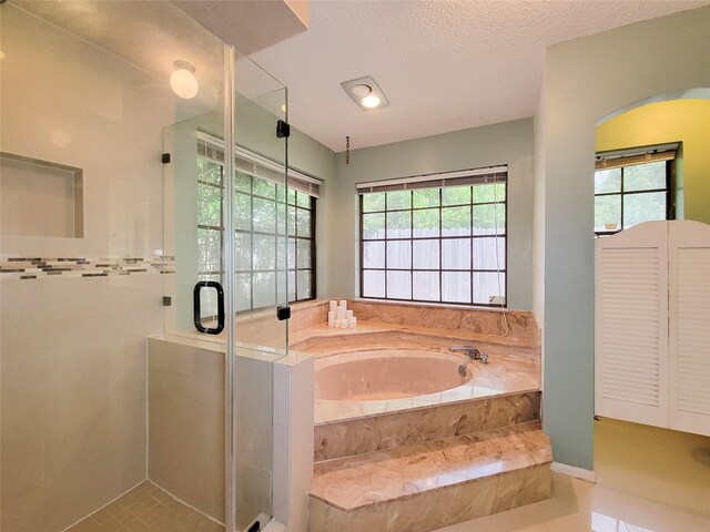 3 Thunderbird Cir, Baytown, TX 77521 - full bath with a shower stall, a bath, plenty of natural light, and a textured ceiling